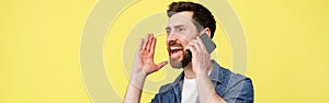 Happy man shouting loudly while talking on the phone and gesturing with his hands