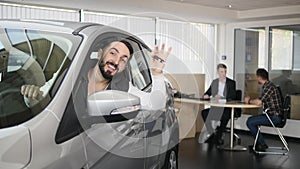 Happy man showing the key of his new car. Auto business, car sale, technology and people concept - happy male with car