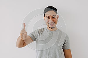 Happy man shows thumb up as a good hand sign isolated on white background.