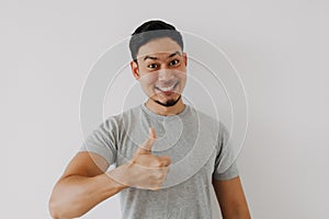 Happy man shows thumb up as a good hand sign  on white background.