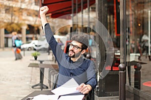 Happy man sitting at cafe table