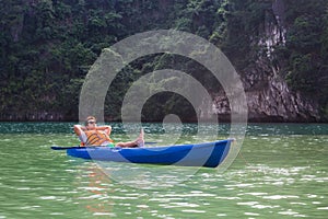 A happy man sitting in a kayak boat on a lake relaxing