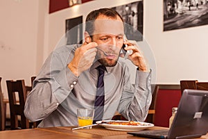 Happy man sitting in restaurant with laptop