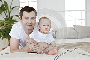 happy man with a small child on the bed, in the bedroom. father and son family