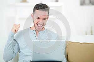 Happy man smiling in front laptop