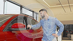 Happy man smiling to the camera after buying new car