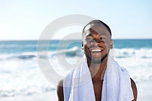 Happy man smiling with towel at the beach