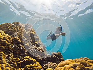 Happy man in snorkeling mask dive underwater with tropical fishes in coral reef sea pool. Travel lifestyle, water sport