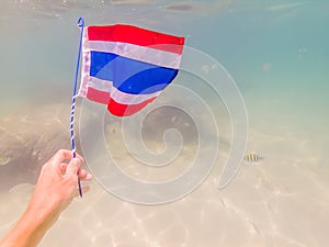 Happy man in snorkeling mask dive underwater with tropical fishes with thailand flag in coral reef sea pool. Travel