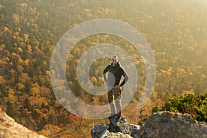 Happy man standing at the top of the mountain. Landscape view of misty autumn mountain hills and man silhouette