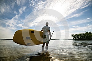 Happy man stands with a SUP board