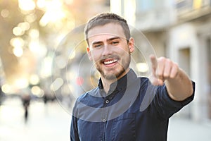 Happy man in the street pointing at camera