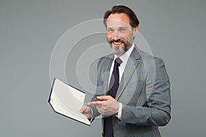 Happy man in suit with book. accountant maintains accounting records. making notes in notebook. View the to-do list in photo