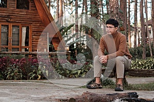 Happy man in sweater traveling in pine tree forest, tourist visit at Doi Bo Luang, Chiang Mai, Thailand, Landmark and popular for