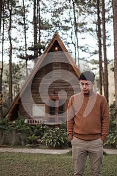 Happy man in sweater traveling in pine tree forest, tourist visit at Doi Bo Luang, Chiang Mai, Thailand, Landmark and popular for