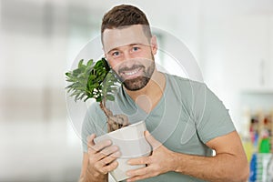 happy man takes care indoor plants