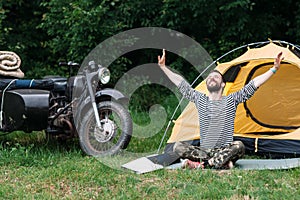 Happy man taking sunbath in forest