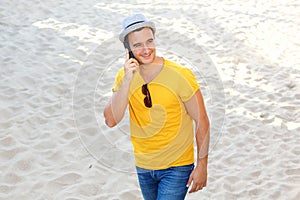 Happy man talking on cellphone at the beach