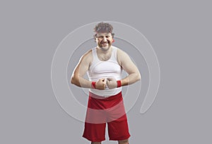 Happy man in tank top and shorts smiling and flexing his arms showing his muscles