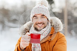 Happy man with tea cup outdoors in winter