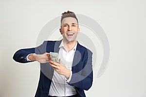Happy man throwing money on grey background. Space for text