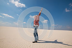 Happy man, traveler with open arms enjoying amazing world in desert