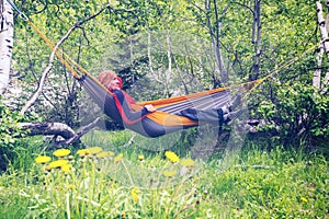 Happy man traveler is relaxing in hammock