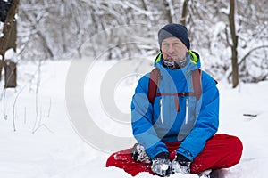 Happy man, traveler relaxing meditating in the winter forest