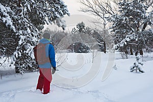 Happy man, traveler walking in the winter forest