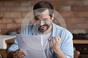 Happy man triumph reading good news in letter