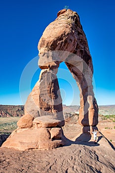 Happy man under Delicate Arch in Arches National Park, wide angle view