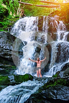 Happy man unger mountain waterfall