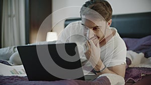 Happy man using laptop computer at home. Smiling man chatting online on notebook