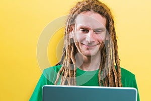 Happy man using a laptop on a solid background