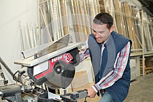 Happy man using sawing circular saw