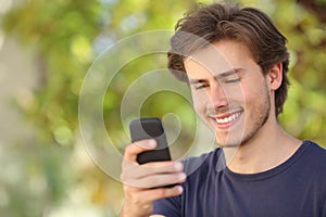 Happy man using a smart phone outdoor
