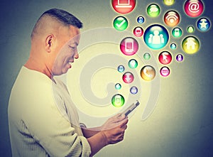 Happy man using texting on smartphone social media application icons flying up