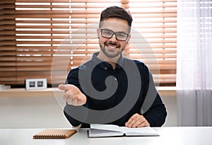 Happy man using video chat in office, view from web camera