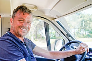 Happy man van driver behind steering wheel of car driving concept