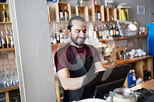 Happy man or waiter at bar cashbox