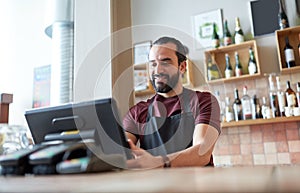 Happy man or waiter at bar cashbox