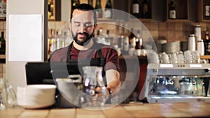 Happy man or waiter at cashbox in coffee shop