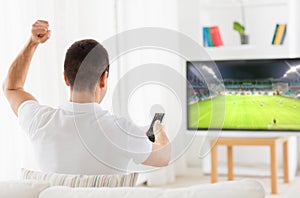 Happy man watching football or soccer game on tv