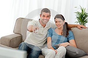 Happy man watching tv with his girlfriend sitting