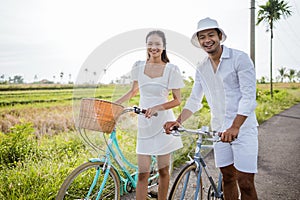 happy man and woman cycling outdoor smiling to camera