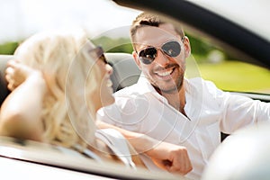 Happy man and woman driving in cabriolet car