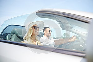 Happy man and woman driving in cabriolet car