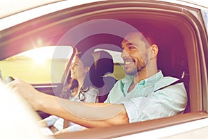 Happy man and woman driving in car