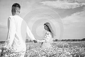 happy man and woman in love enjoy spring weather. happy relations. girl and guy in field. bride and groom. romantic