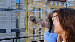 Happy man and woman making selfie on the smartphone while enjoying the party on the rooftop with friends. Lifestyle, fun